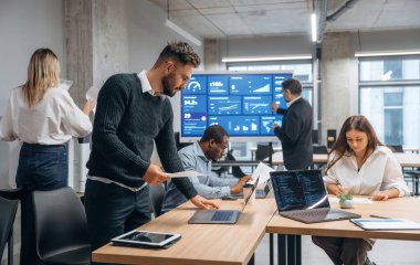 Masanın yanında. Bir grup ofis çalışanı içeride birlikte..