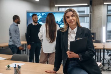 Kadının ön görüntüsü. Bir grup ofis çalışanı içeride birlikte..