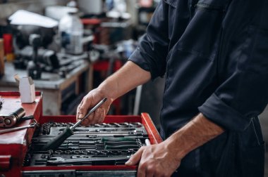 Bir sürü aleti olan bir masa. Araç servis istasyonundaki tamircinin görüntüsünü kapat.