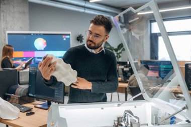 Ayakta. Modern teknoloji. Ofiste 3D yazıcının yanında insanlar var..