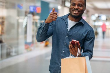 Parmağını kaldır, çantaları tut. Siyah adam süpermarketin holünde..