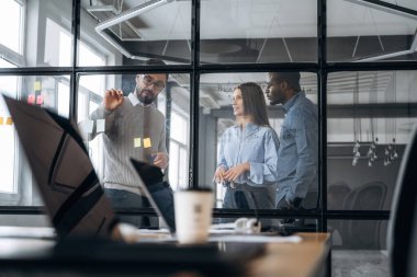 Taktikler, işi planlamak. Profesyonel işçiler modern ofiste birlikte çalışıyorlar..