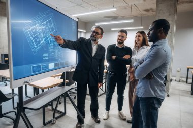 Bina planı ekranda. Bir grup ofis çalışanı içeride birlikte..