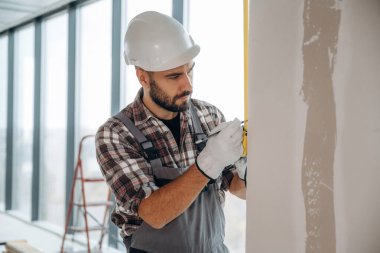 İşime odaklandım. Bir adam bitmemiş bir odayı yeniliyor..