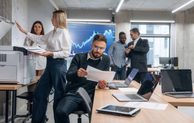 Yazıcı kullanıyor. Bir grup ofis çalışanı içeride birlikte..