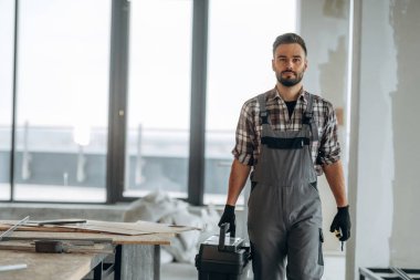 Aletlerle, aletlerle dolu bir kutu. Bir adam bitmemiş bir odayı yeniliyor..