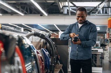 Elektrikli süpürge. Ev gereçleri dükkanındaki adam..