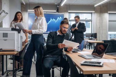 Yazıcı kullanıyor. Bir grup ofis çalışanı içeride birlikte..