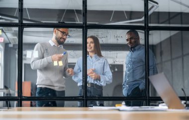 Taktikler, işi planlamak. Profesyonel işçiler modern ofiste birlikte çalışıyorlar..