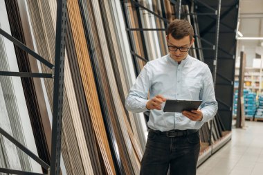 Müdür not defteriyle birlikte. Erkek hırdavatçı dükkanında çalışıyor..