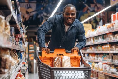 Gülümseyen, pozitif yüz ifadesi. Erkek müşteri süpermarkette..