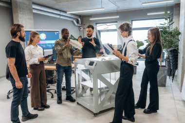 Ofiste 3D yazıcının yanında insanlar var..