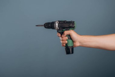 Adamın eli arka planda profesyonel matkap tutuyor..