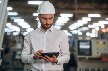 Modern dijital tablet. İnsanlar modern fabrikada çalışıyor..