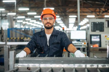 Metal parçalar, ayakta duruyor. İnsanlar modern fabrikada çalışıyor..