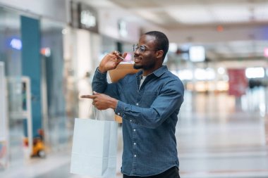 Alışveriş zamanı. Siyah adam süpermarketin holünde..