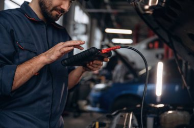 Dijital tablet bağlanıyor. Araba tamirhanesinde çalışan bir tamirci..