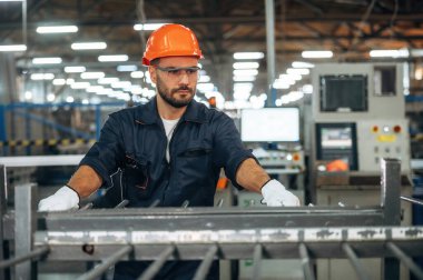 Metal parçalar, ayakta duruyor. İnsanlar modern fabrikada çalışıyor..