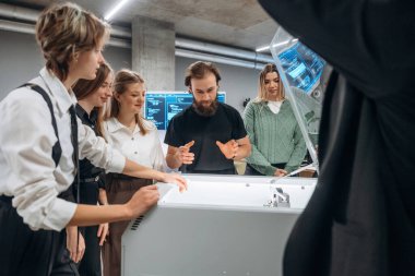 Ofisteki 3D yazıcının etrafında bir grup insan duruyor..