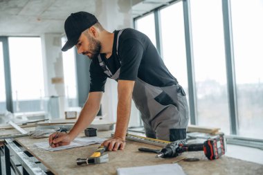 Aletli masa. Bir adam bitmemiş bir odayı yeniliyor..