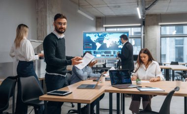 Masanın yanında. Bir grup ofis çalışanı içeride birlikte..