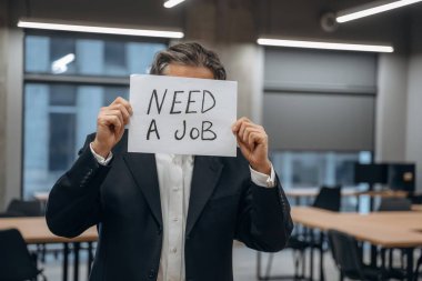 İş arıyorum, pankart tutuyorum. Kıdemli adam modern ofiste..