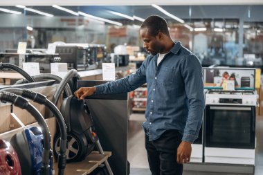 Elektrikli süpürge. Ev gereçleri dükkanındaki adam..