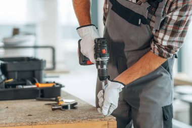 Odaklanın, aletler. Bitmemiş odayı yenileyen işçinin yakın görüntüsü.