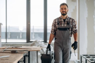 Aletlerle, aletlerle dolu bir kutu. Bir adam bitmemiş bir odayı yeniliyor..