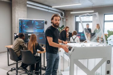 Ofiste 3D yazıcının yanında insanlar var..