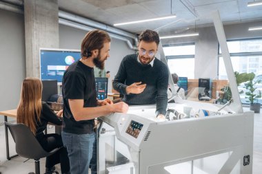 3D yazıcıyı gösteriyor. Ofiste insanlar var..