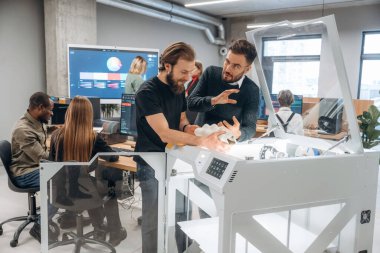 Modern teknoloji. Ayakta. Ofiste 3D yazıcının yanında insanlar var..