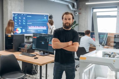 Ön manzara, ayakta ve poz veriyor. Ofiste 3D yazıcının yanında insanlar var..