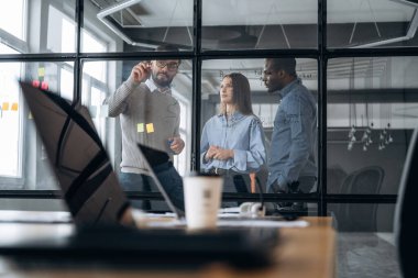 Taktikler, işi planlamak. Profesyonel işçiler modern ofiste birlikte çalışıyorlar..