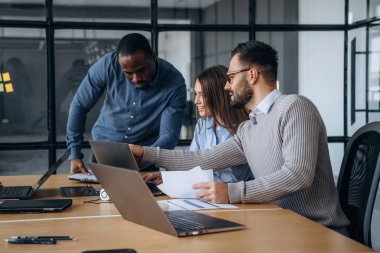 İnsanların çeşitliliği. Profesyonel işçiler modern ofiste birlikte çalışıyorlar..