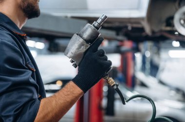 Elimde özel bir alet var. Araba tamirhanesinde çalışan bir tamirci..