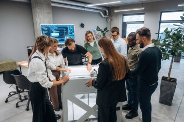 Ofisteki 3D yazıcının etrafında bir grup insan duruyor..