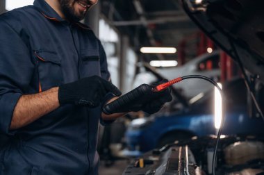 Dijital tablet bağlanıyor. Araba tamirhanesinde çalışan bir tamirci..