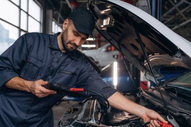 Dijital tablet bağlanıyor. Araba tamirhanesinde çalışan bir tamirci..