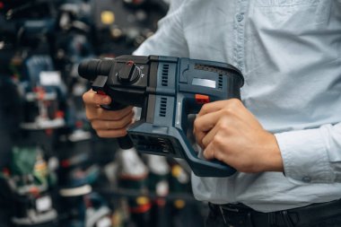 Perforatör matkabı. Hırdavatçıda adamın elinin detaylı yakın görüntüsü..