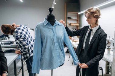 Moda konsepti. İnsanlar içeride dikiş makinelerinin yanında çalışıyor..