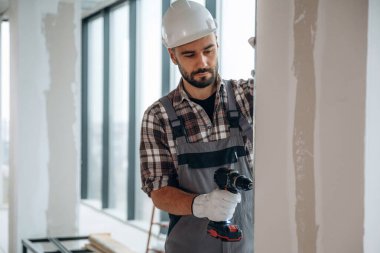 Duvarı deliyorum. Bir adam bitmemiş bir odayı yeniliyor..