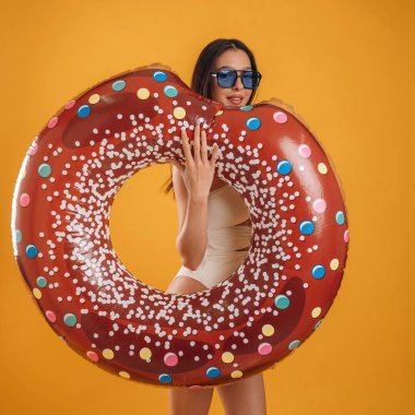 Yüzme yüzüğüne benziyor. Genç ve güzel bir turist kadın arka plana karşı..