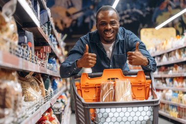 Gülümseyen, pozitif yüz ifadesi. Erkek müşteri süpermarkette..