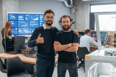 Ön manzara, ayakta ve poz veriyor. Ofiste 3D yazıcının yanında insanlar var..