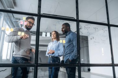 Projeyi planlıyorum. Profesyonel işçiler modern ofiste birlikte çalışıyorlar..