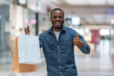 Parmağını kaldır, çantaları tut. Siyah adam süpermarketin holünde..