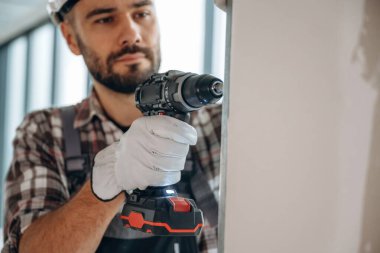 Duvarı deliyorum. Bir adam bitmemiş bir odayı yeniliyor..