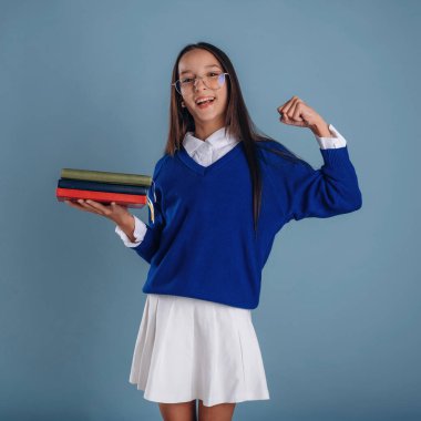 Okul için hazır, kitaplarla. Üniformalı genç kız arka plana karşı..
