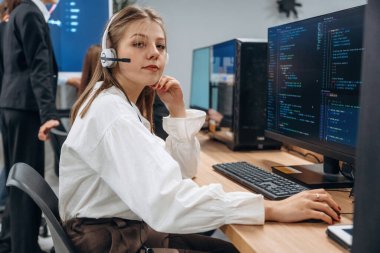 Bilgisayarların başında oturuyor. Tasarımcı takımı ofiste birlikte..